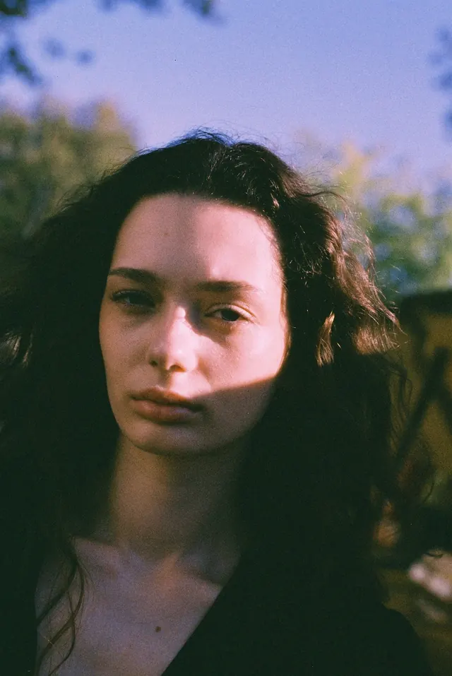 Close portrait outdoors, with a diagonal band of shade across the face.