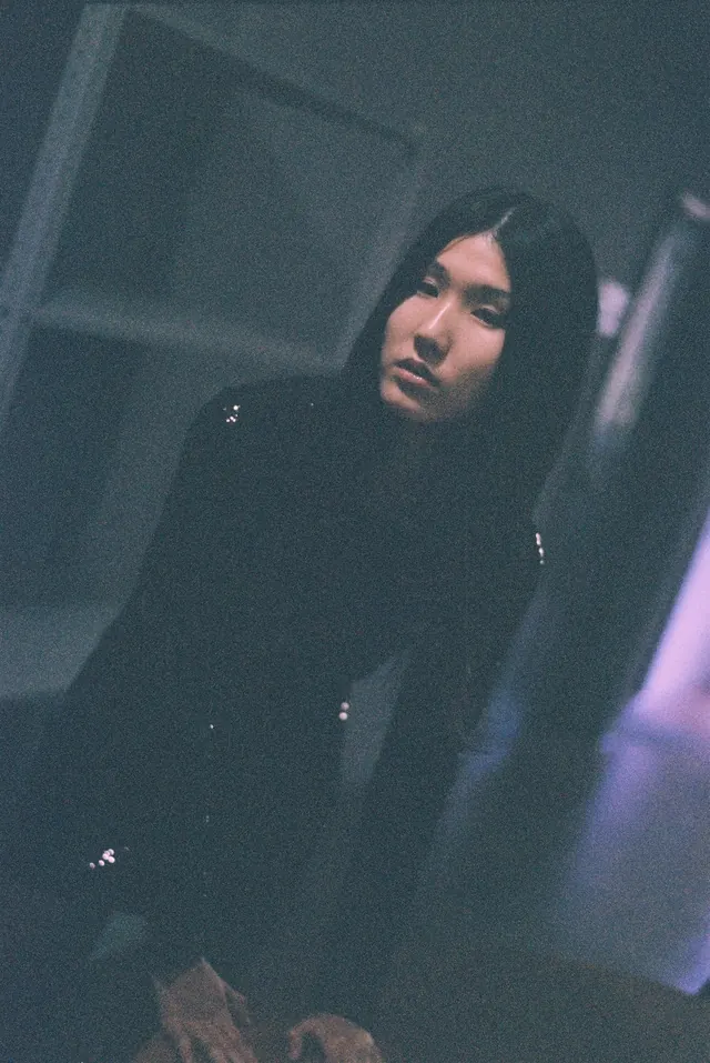 Portrait in black in a dark interior with a tilted composition.